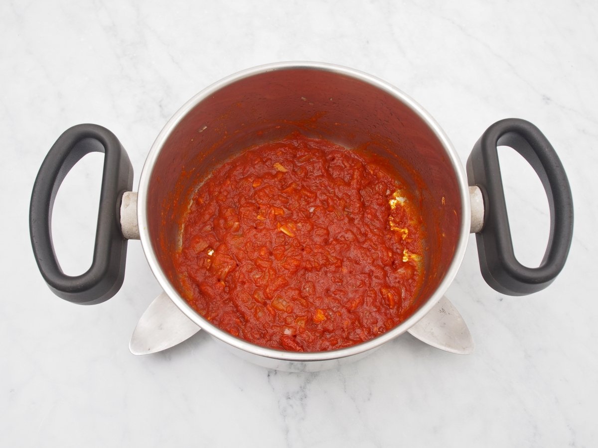 Añadir el pimentón a la cebolla y ajos pochados para hacer la salsa brava