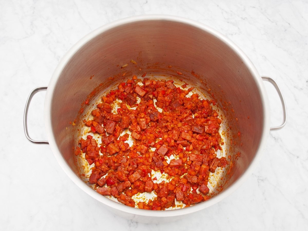 Añadir el pimentón y el tomate al sofrito de las lentejas con jamón
