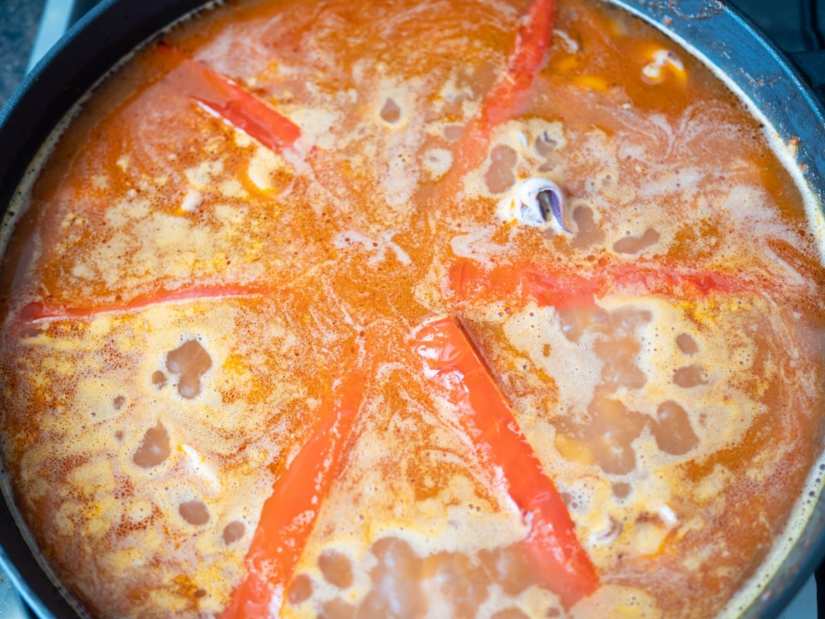 Añadir el pimiento en el arroz con pimiento rojo y calamares