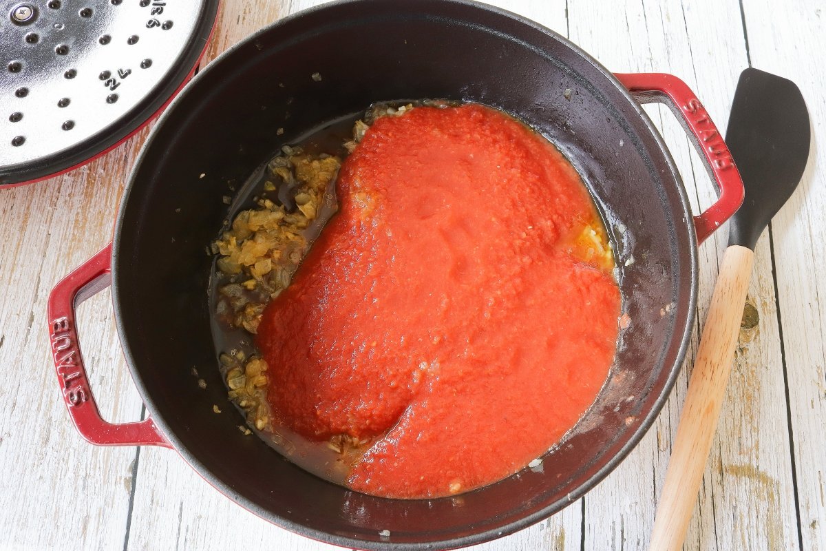 Añadir el tomate a la salsa de las albóndigas de berenjena