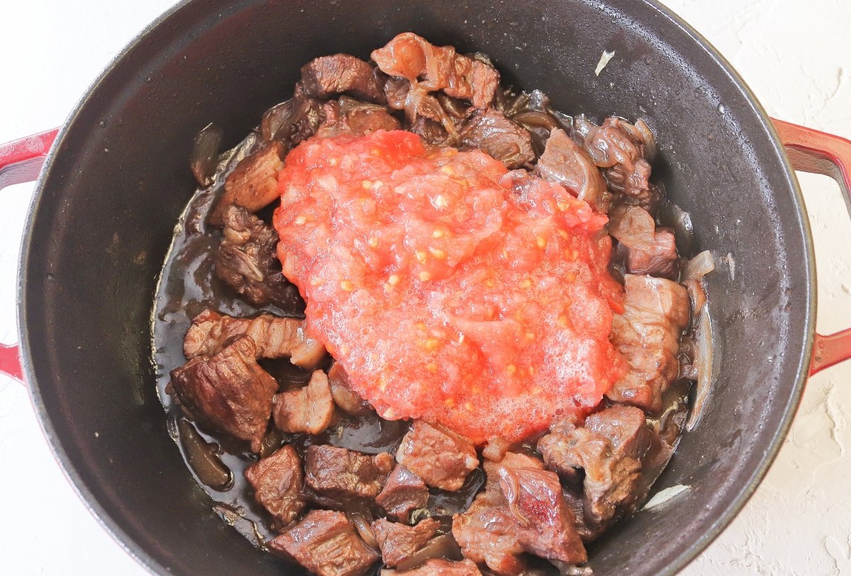 Añadir el tomate a las patatas de Olot