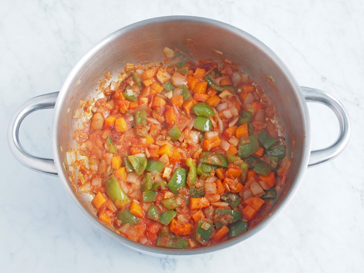 Añadir el tomate al sofrito de la sopa de marisco