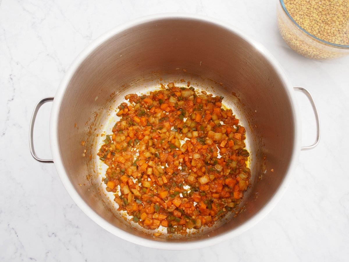 Añadir el tomate al sofrito de las lentejas con acelgas