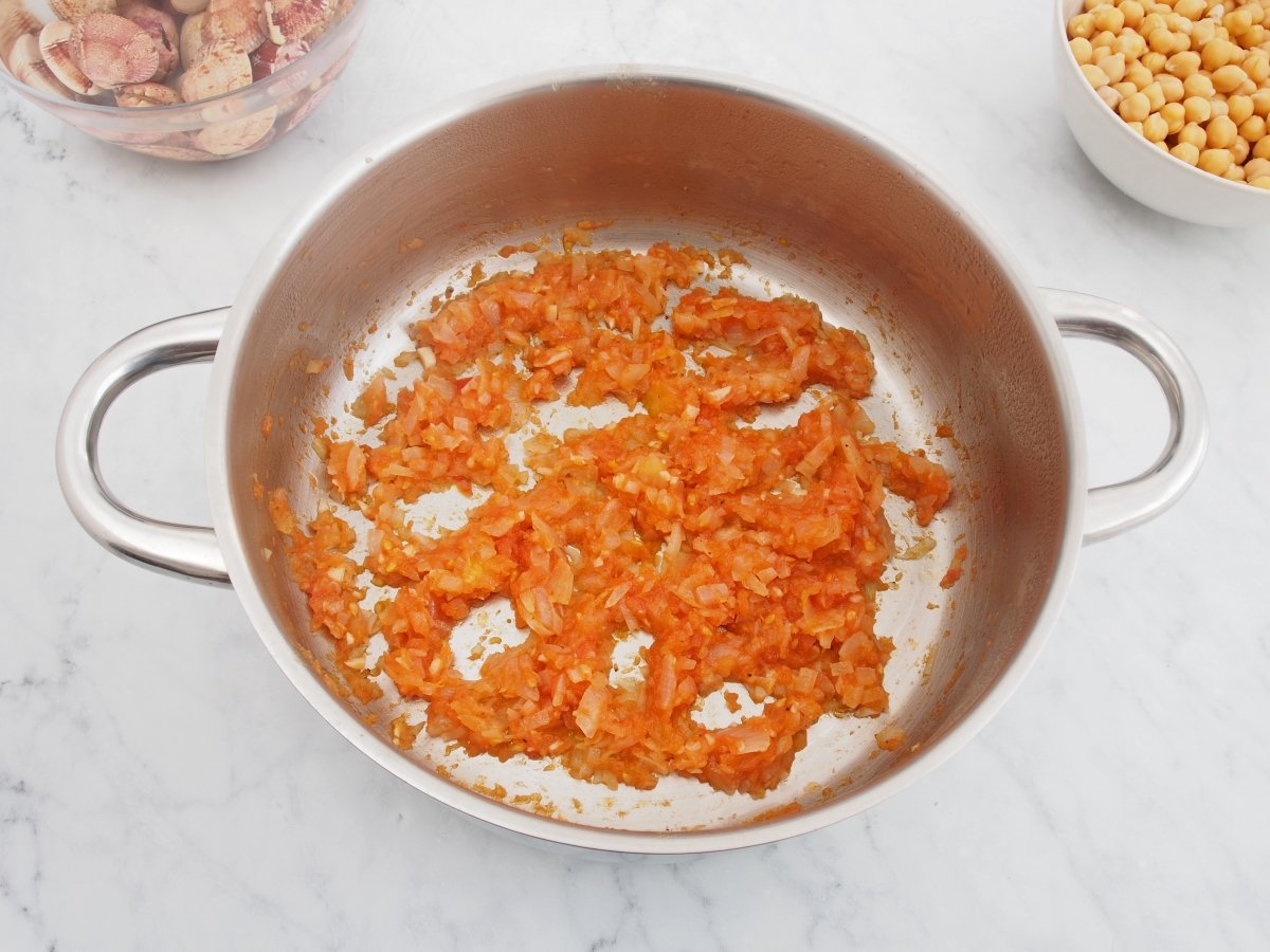 Añadir el tomate al sofrito de los garbanzos con almejas