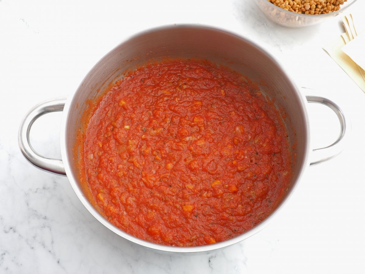 Añadir el tomate al sofrito del relleno de la lasaña