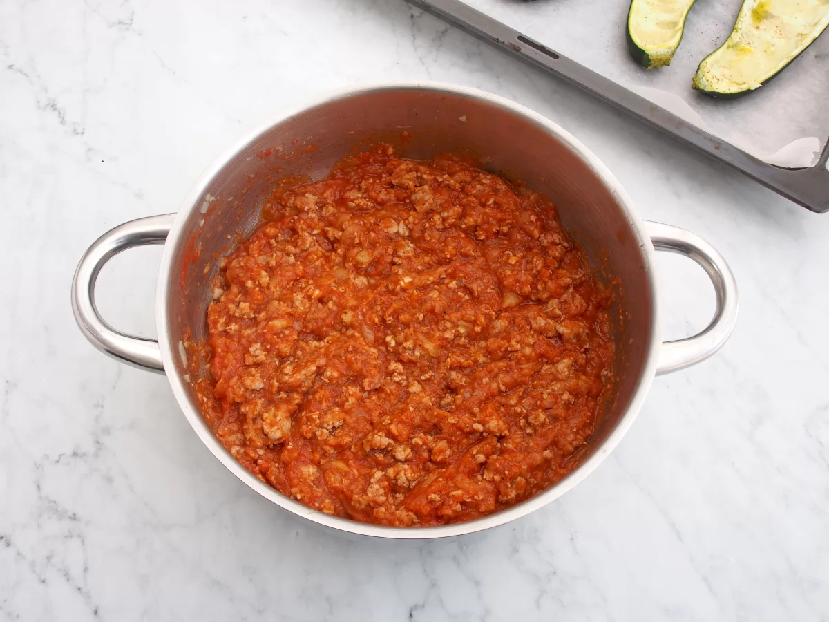 Añadir el tomate al sofrito para los calabacines rellenos de carne