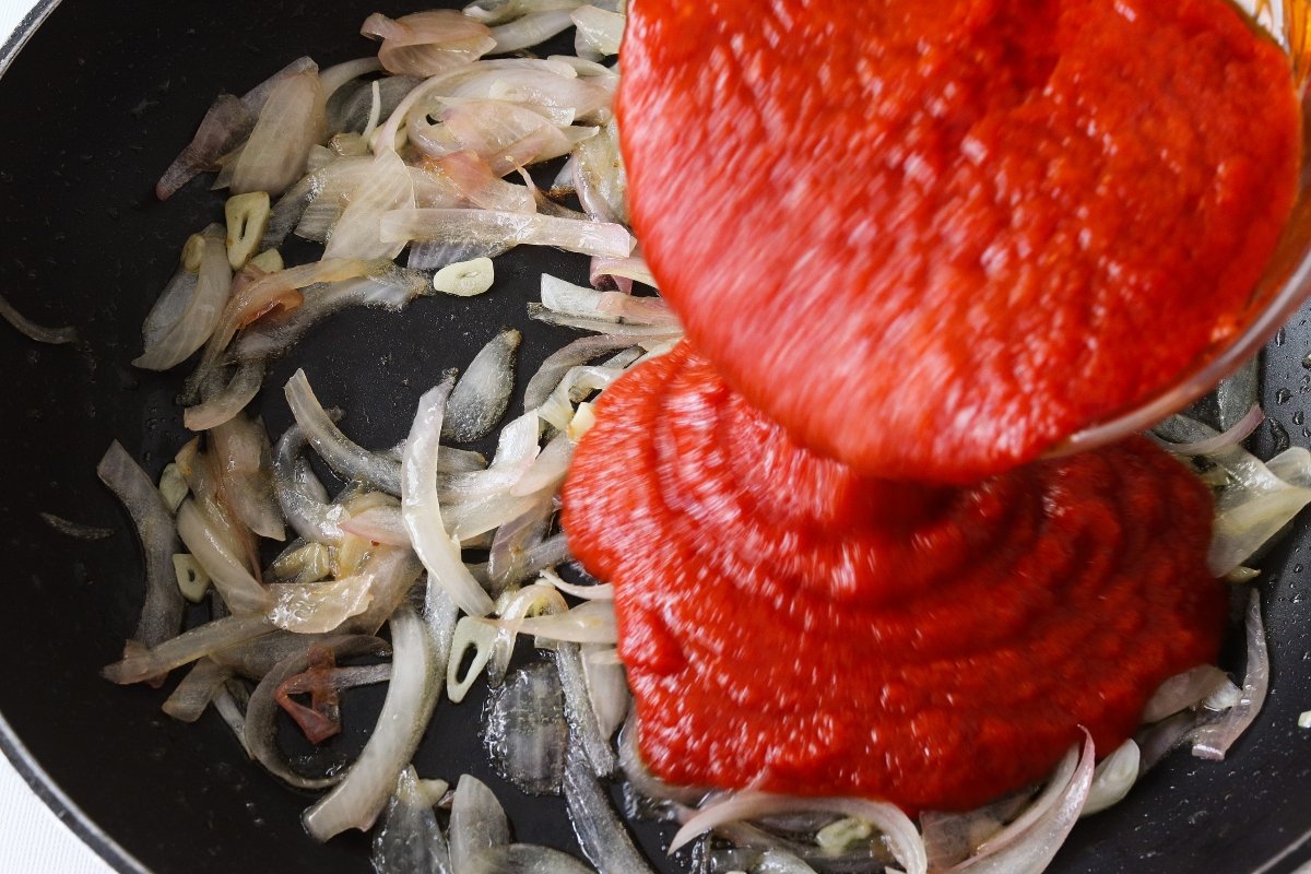 Añadir el tomate frito al bacalao a la riojana