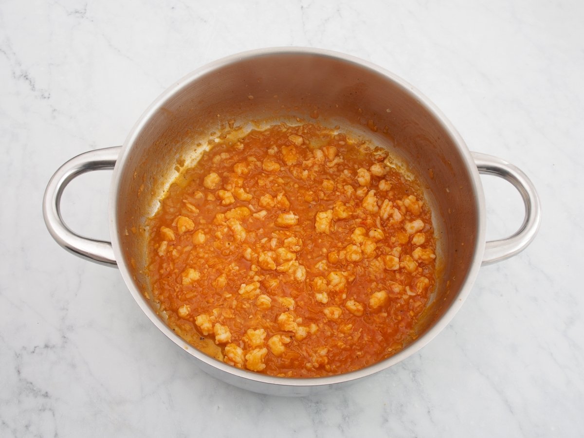 Añadir el tomate frito y el vino para el relleno de los canelones de marisco