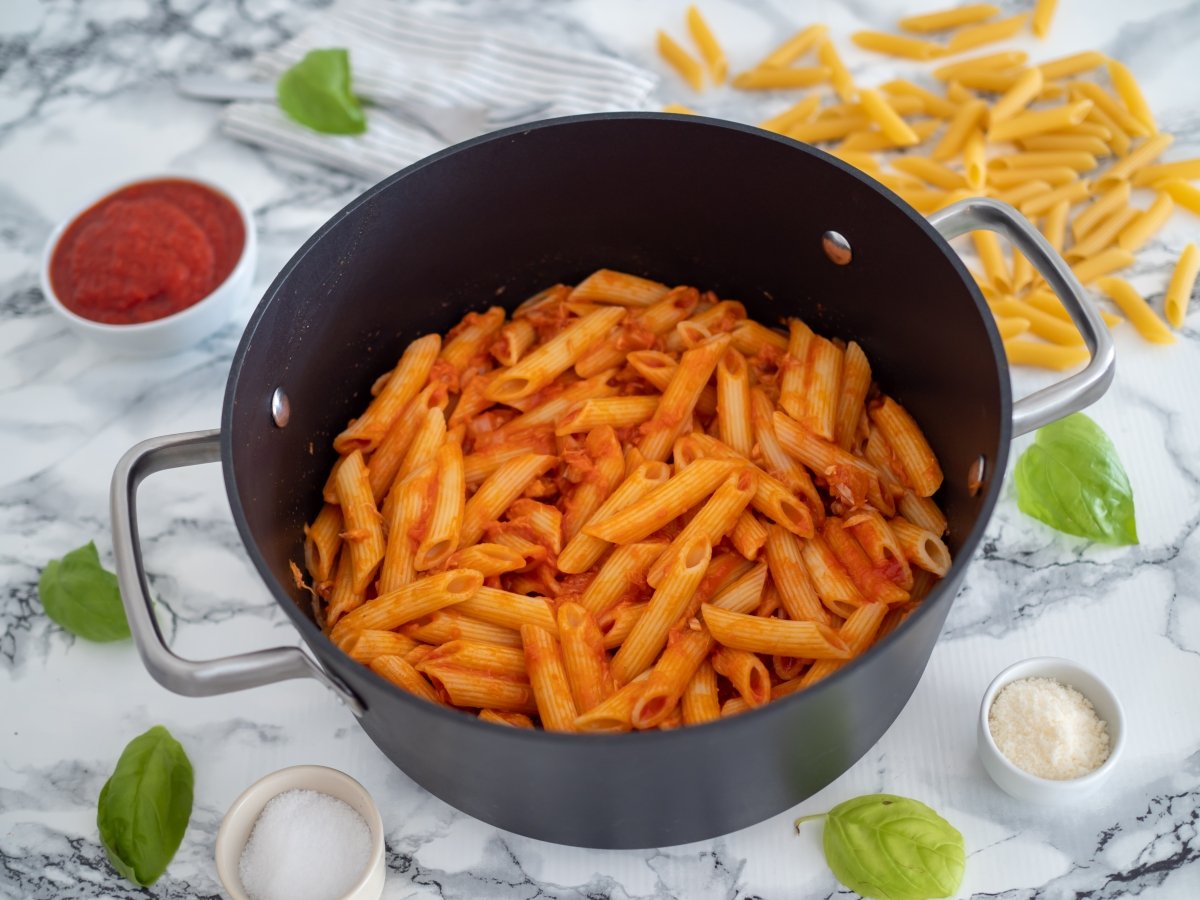 Añadir el tomate frito y mezclar todos los ingredientes para los macarrones con atún y tomate