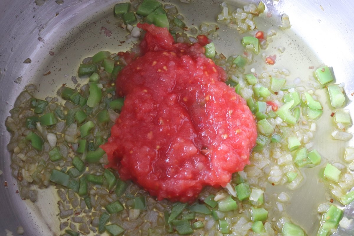 Añadir el tomate rallado para el sofrito del potaje de vigilia