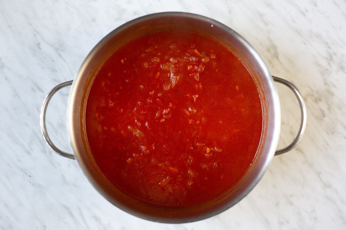 Añadir el tomate triturado y cocinar a fuego lento