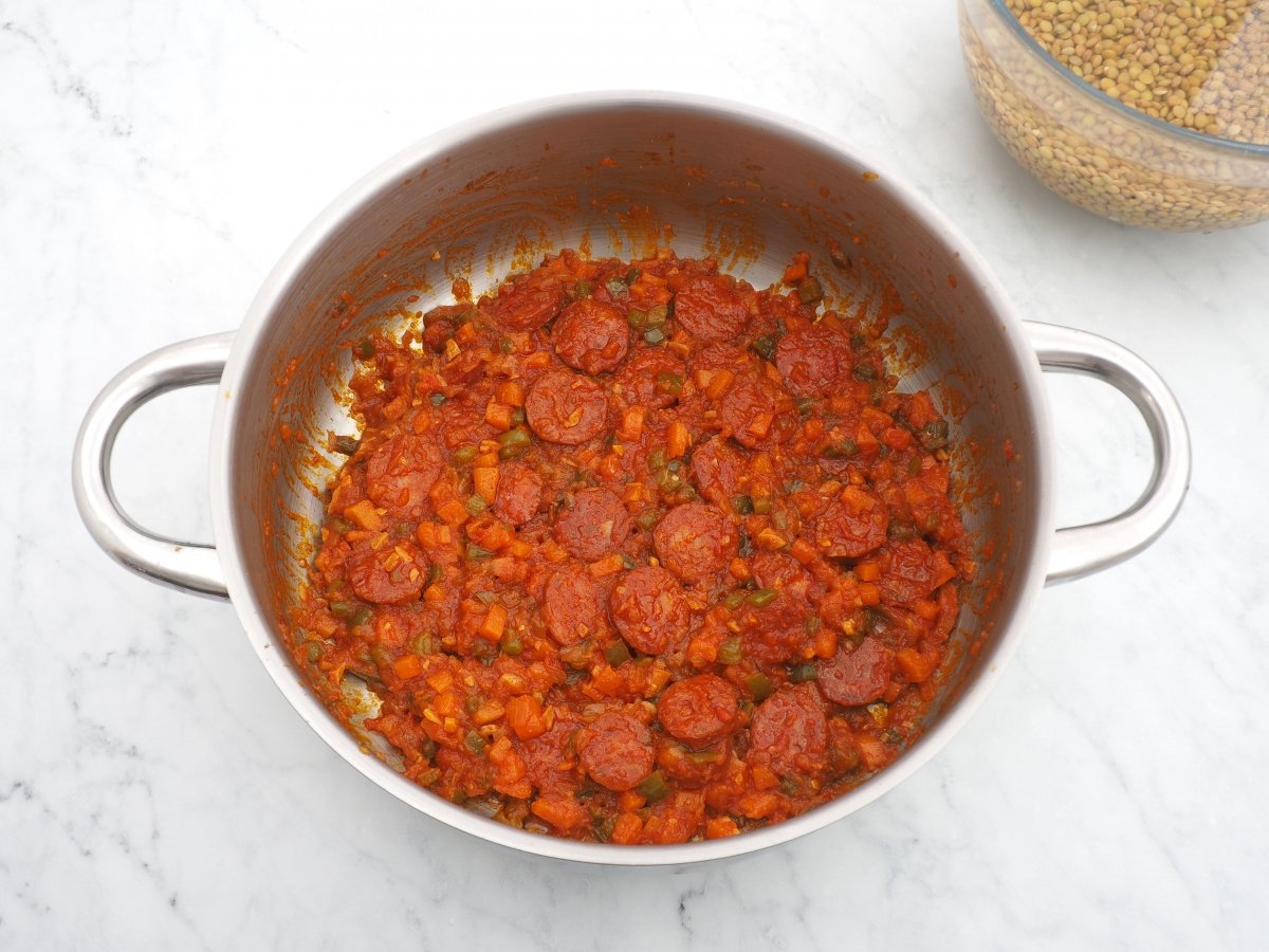 Añadir el tomate y el chorizo al sofrito