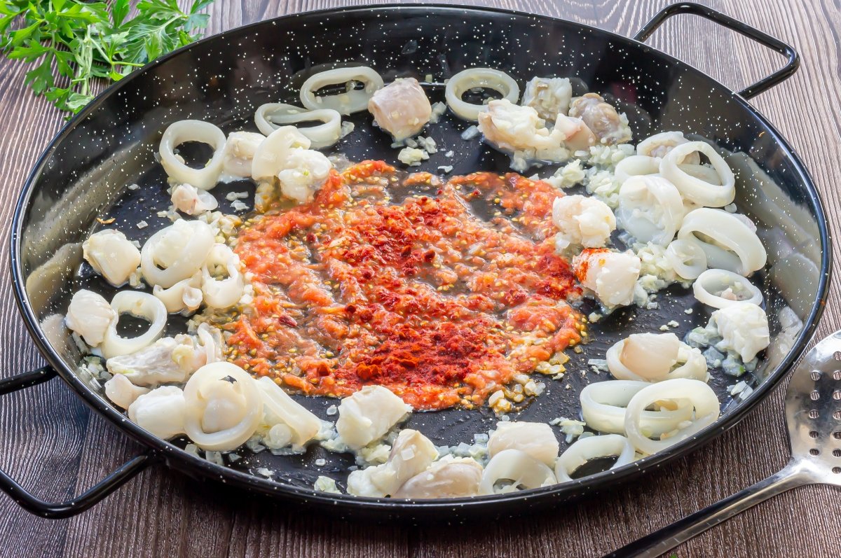 Añadir el tomate y el pimentón al sofrito de la fideuá