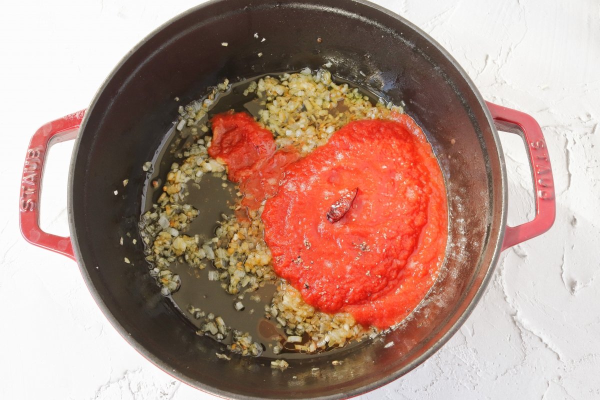 Añadir el tomate y la cayena a los calamares en salsa americana