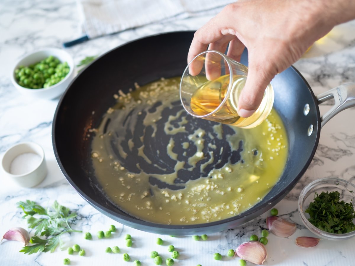 Añadir el vino blanco para la lubina en salsa verde