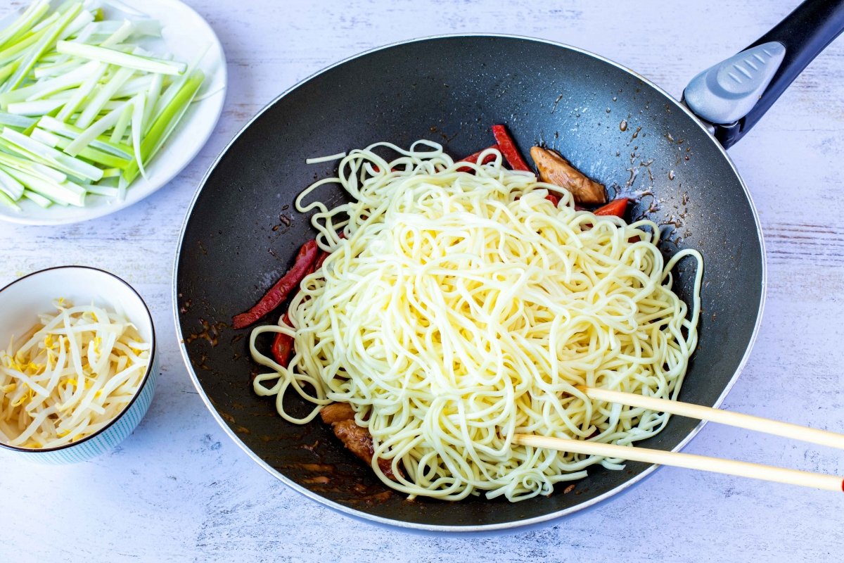 Añadir fideos al wok para hacer los fideos chinos chow mein