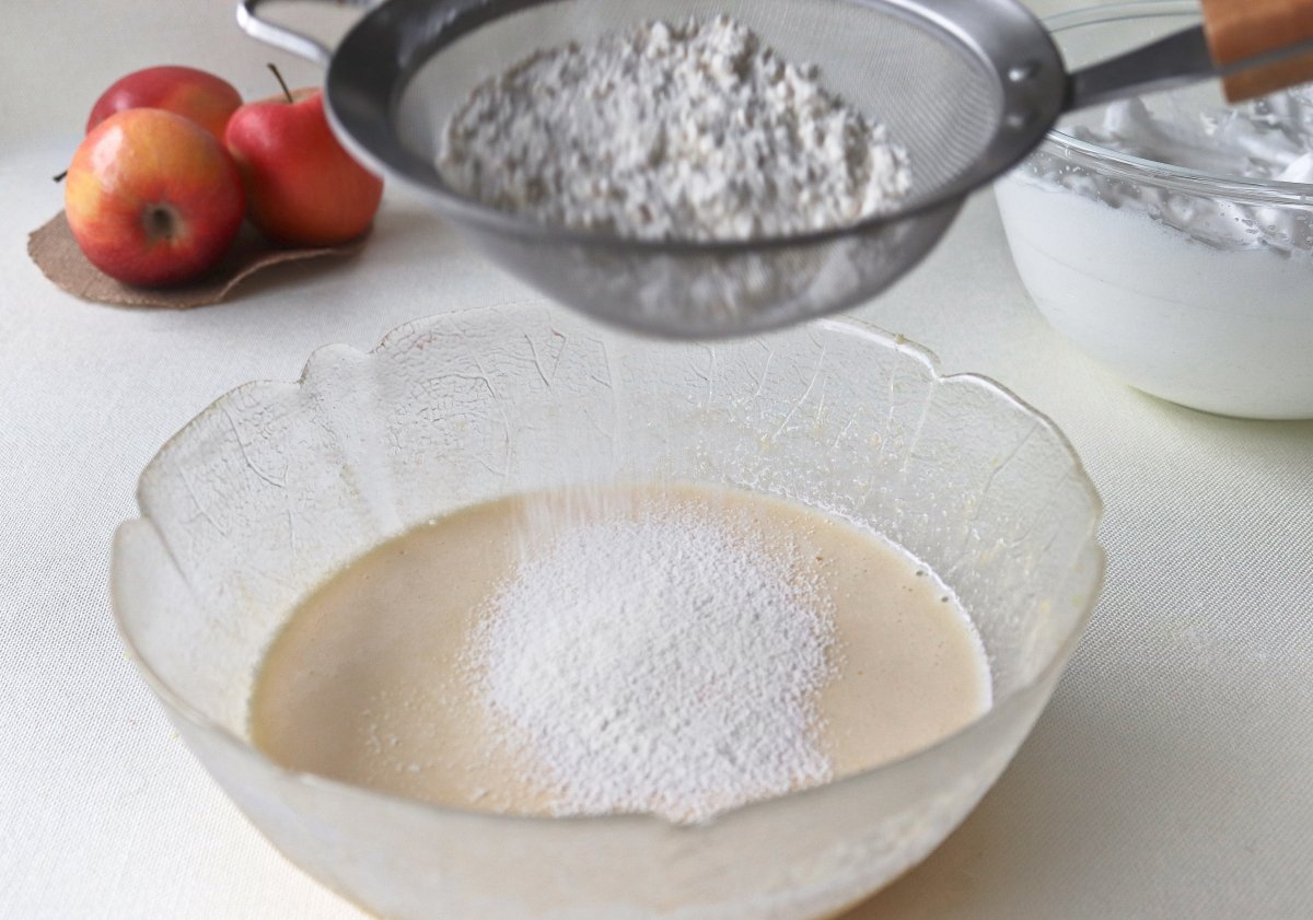 Añadir harina tamizada a la mezcla del bizcocho de manzana