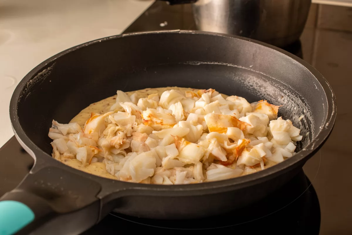 Añadir la carne de la langosta troceada a la salsa de la langosta thermidor