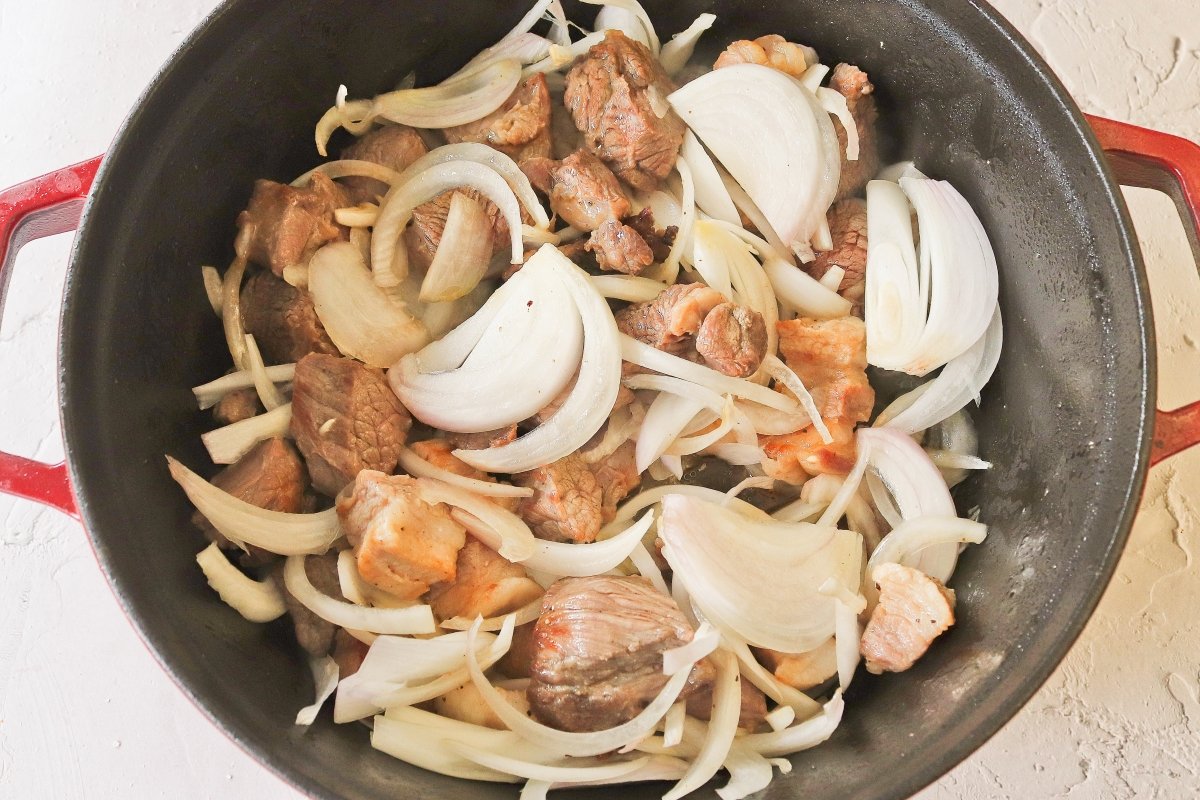 Añadir la cebolla a la carne para las patatas de Olot