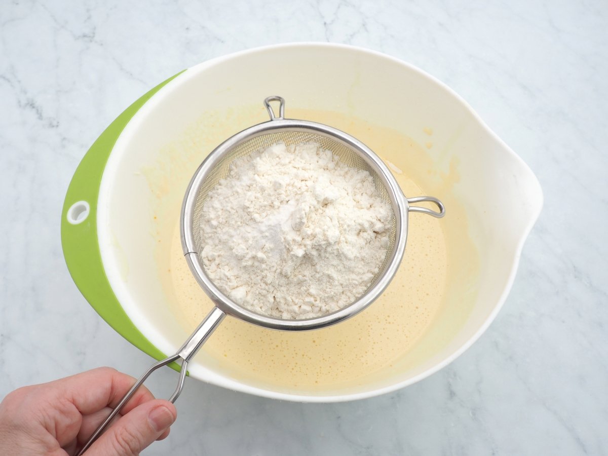 Añadir la harina tamizada a la masa del bizcocho de aceite de oliva