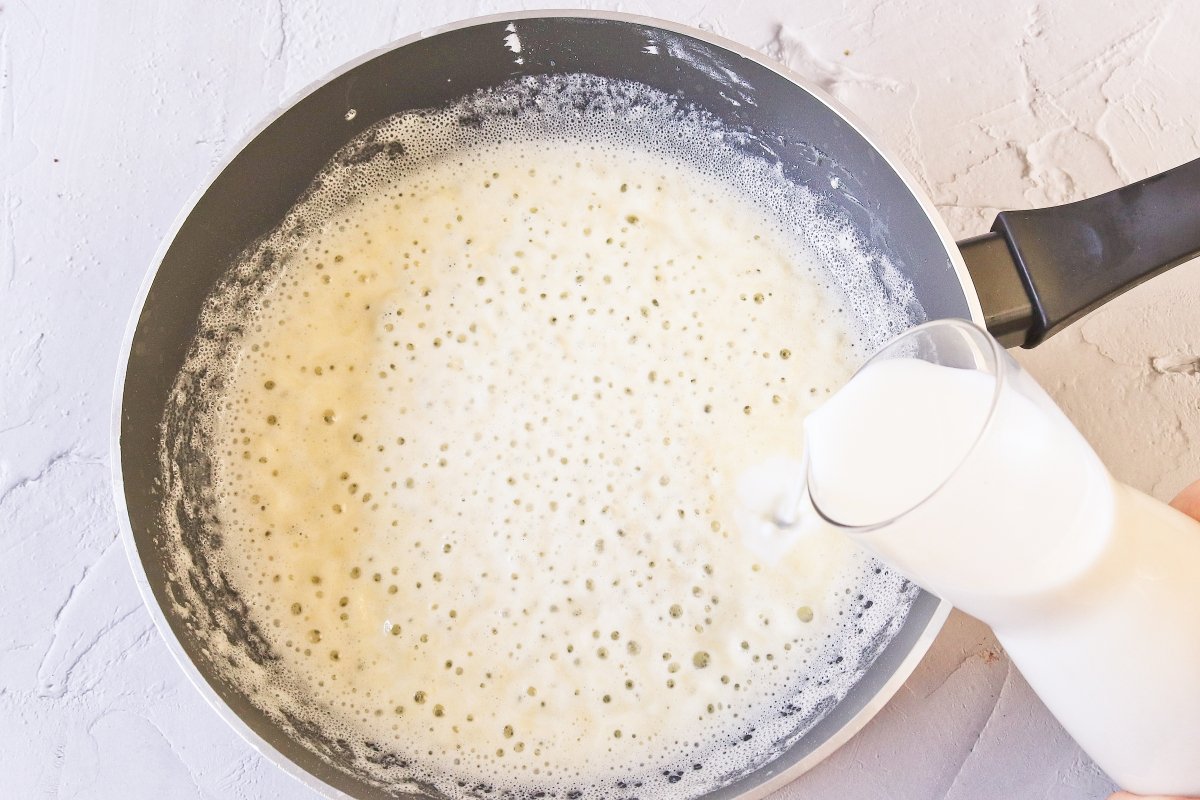 Añadir la leche a la bechamel de la lasaña sin gluten