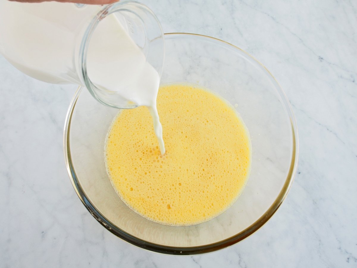 Añadir la leche a la mezcla del flan de naranja