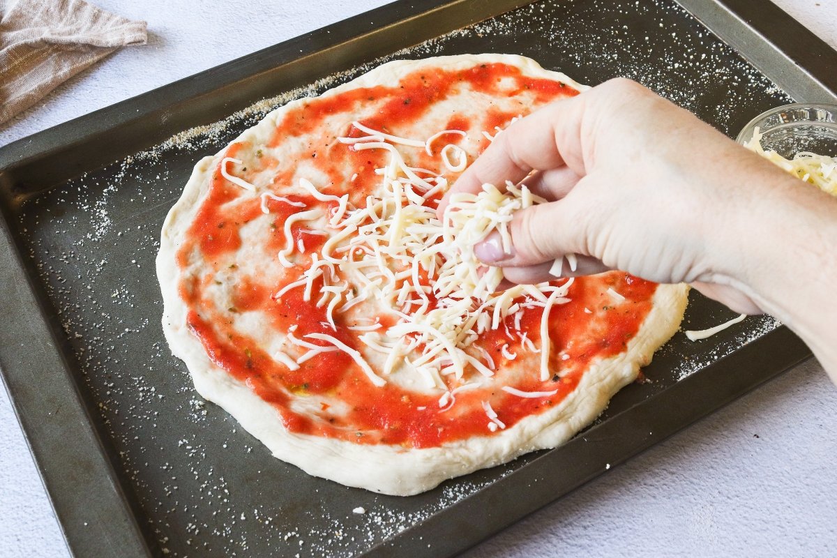 Añadir la mozzarella a la pizza de queso de cabra y bacon