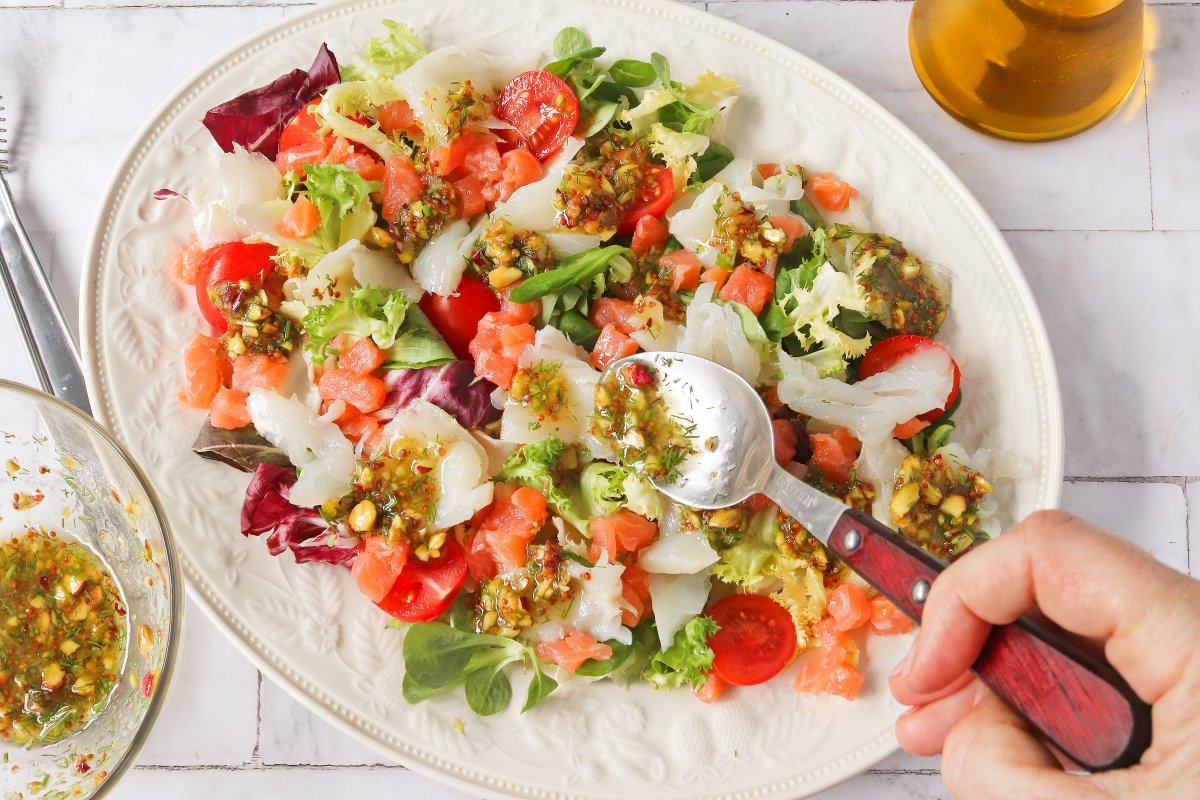 Añadir la vinagreta a la ensalada de ahumados