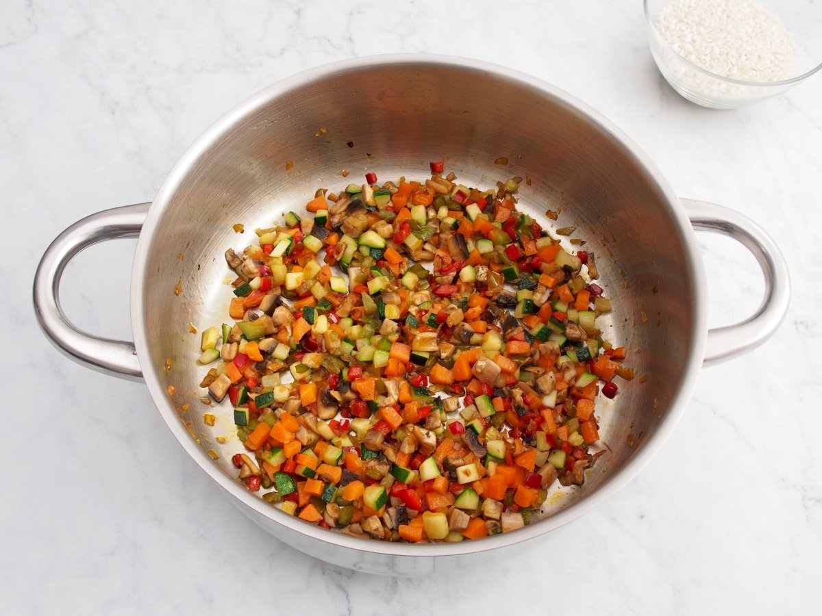 Añadir la zanahoria y el calabacín al sofrito del arroz caldoso de verduras