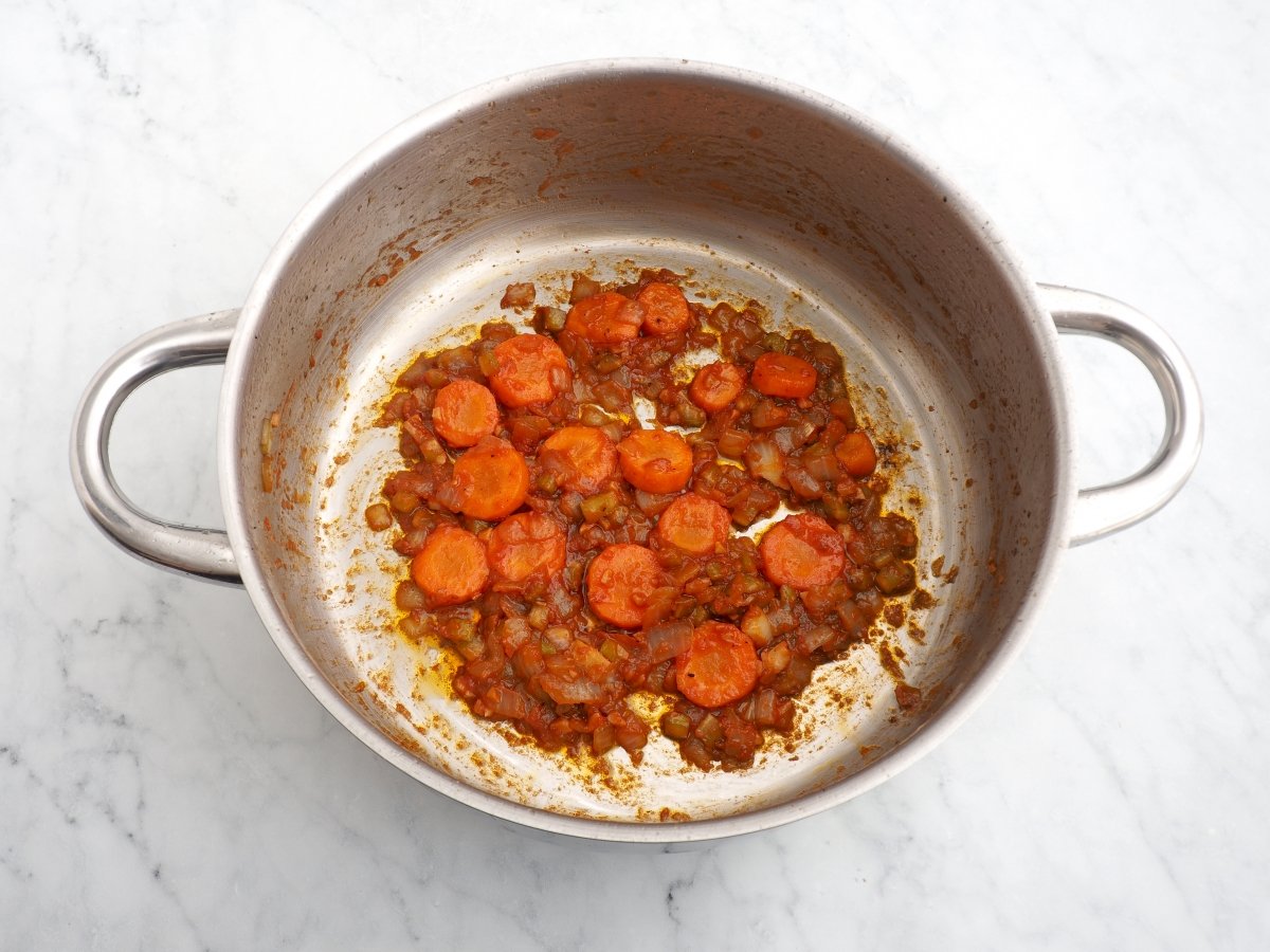 Añadir la zanahoria y el tomate al sofrito