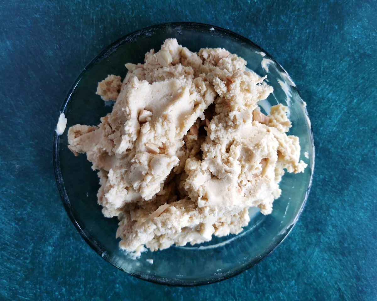 Añadir las almendras molidas y la harina tamizada a la mantequilla, junto con las almendras tostadas