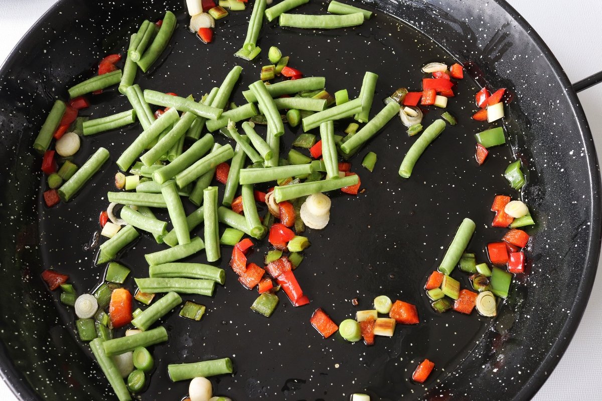 Añadir las judías verdes a la paella de verduras