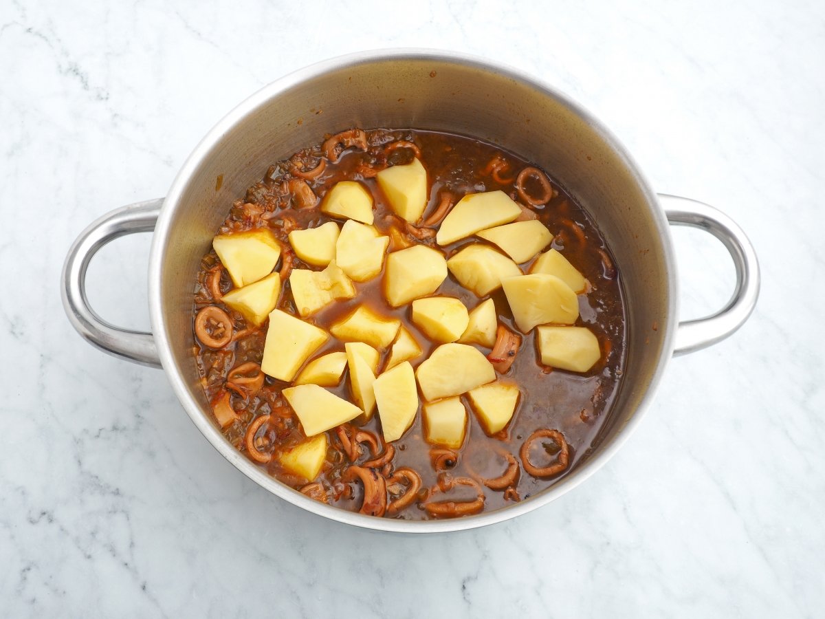 Añadir las patatas al guiso de calamares