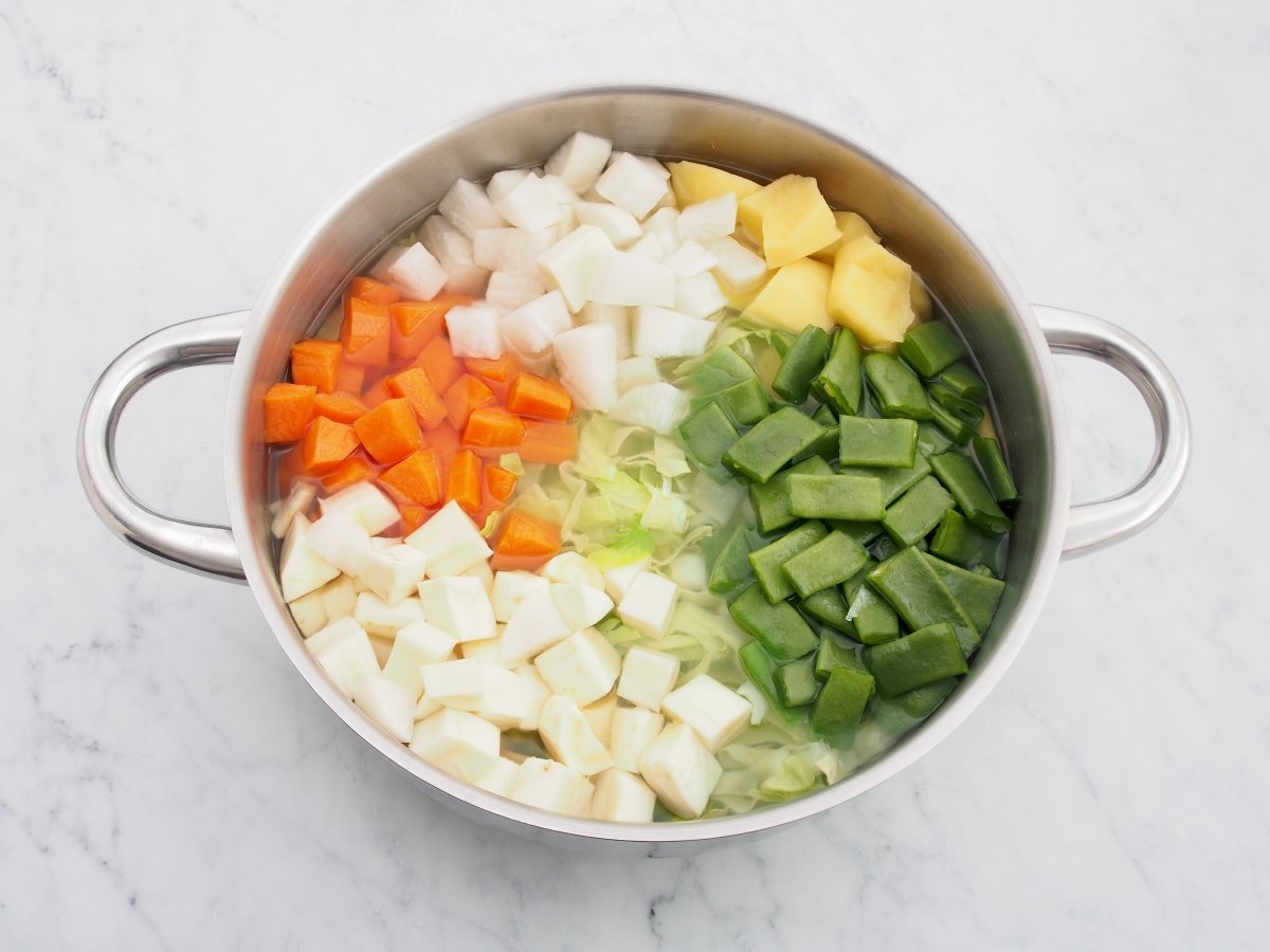 Añadir las verduras a la cazuela de las alubias para la olla de la plana