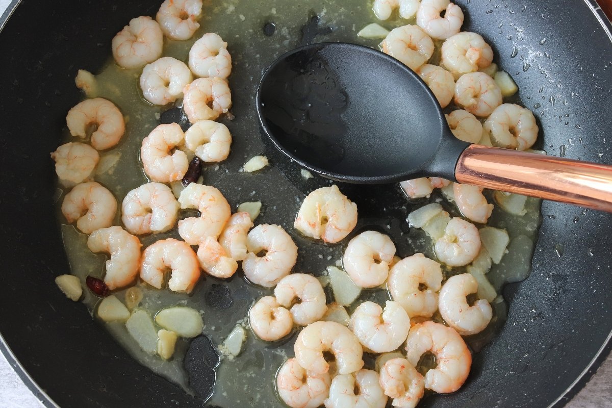 Add the cooking liquid from the spaghetti to the garlic prawns