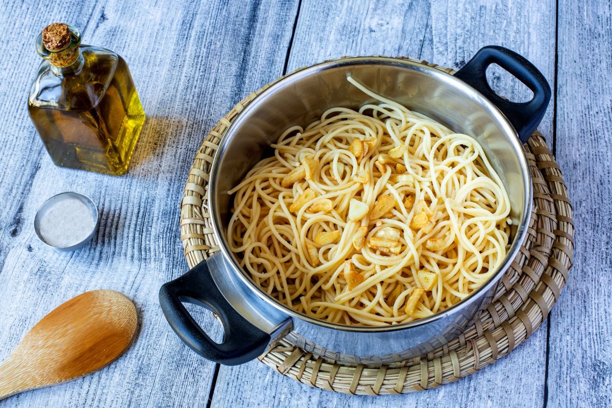 Añadir los ajos dorados a los espaguetis con sardinas