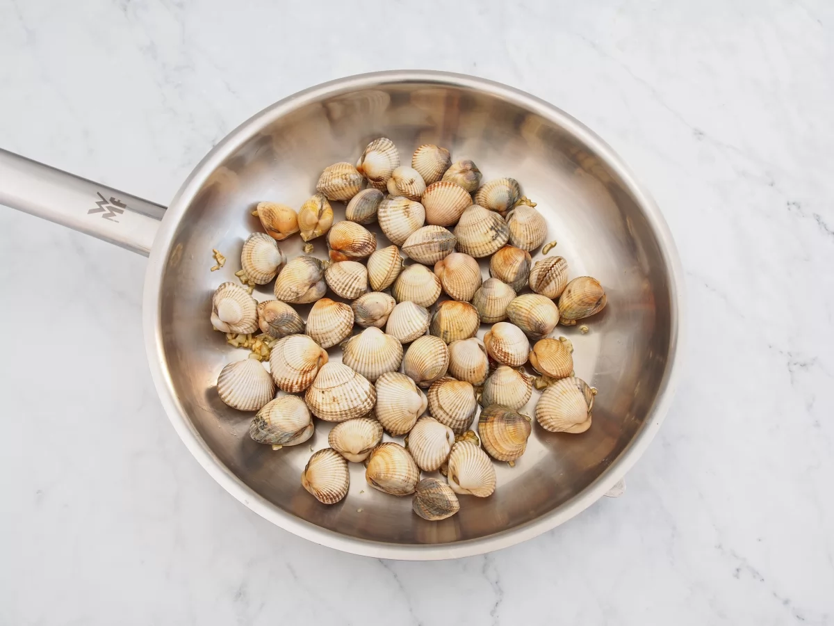 Añadir los berberechos al sofrito de ajo