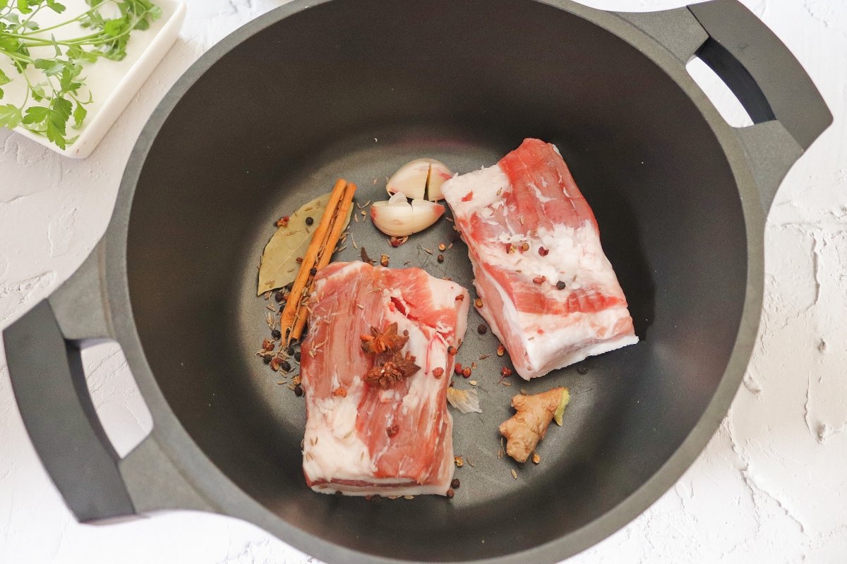 Añadir los condimentos a la panceta para hacer el ssam de cerdo