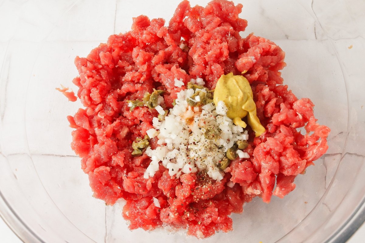 Añadir los ingredientes del aliño al steak tartar