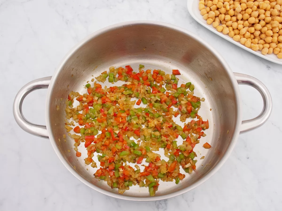 Añadir los pimientos al sofrito de los garbanzos guisados