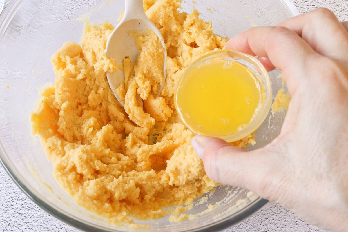 Añadir mantequilla a la masa de maíz de los tamales colombianos