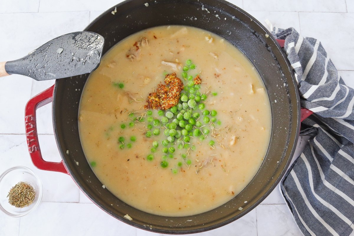 Añadir mostaza, hierbas y guisantes al pastel de pollo