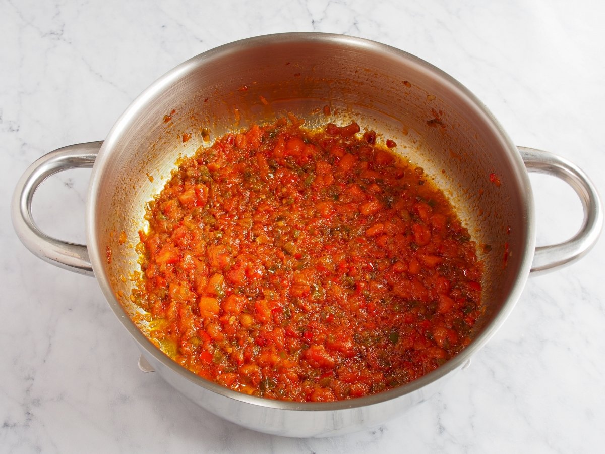 Añadir pimentón dulce, el tomate y pimienta negra. Añadir el vino blanco y dejar que evapore el alco