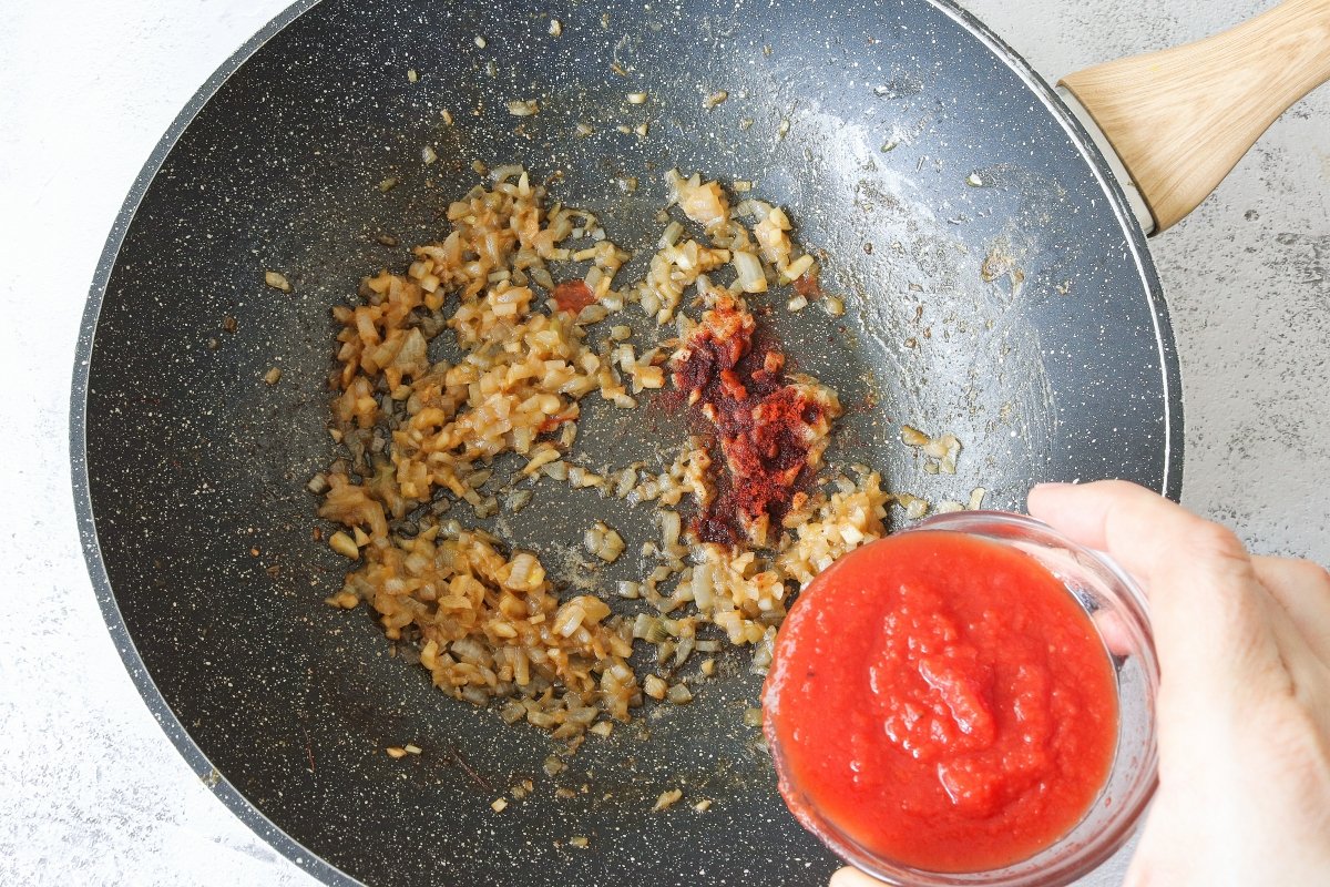 Añadir pimentón y tomate a la cataplana