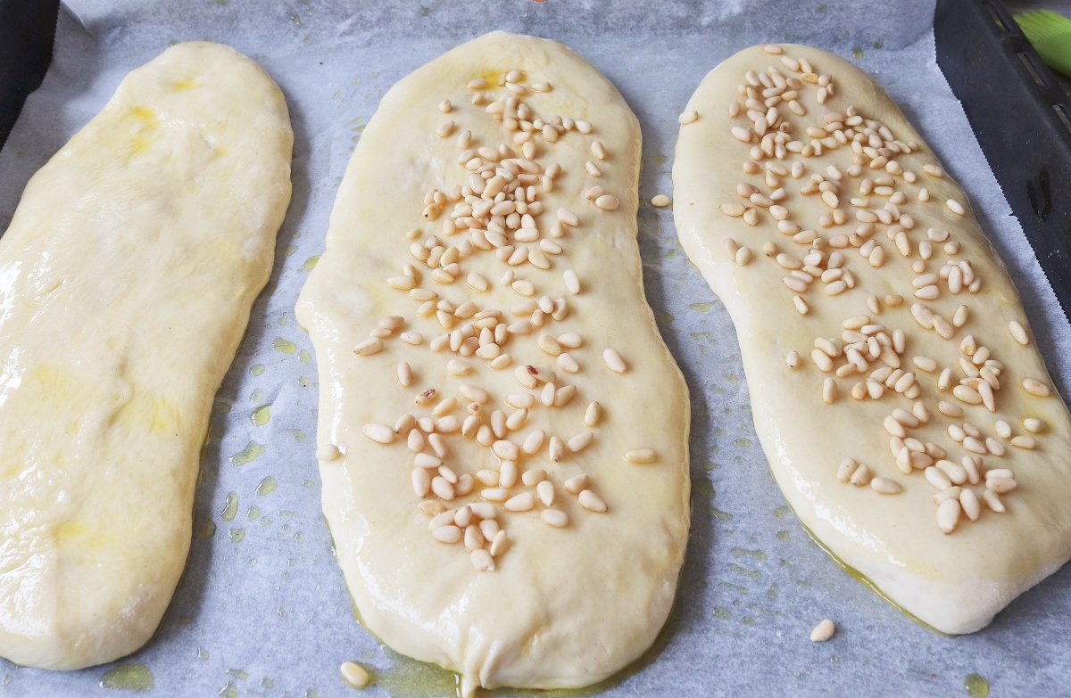 Añadir piñones coca de pan dulce