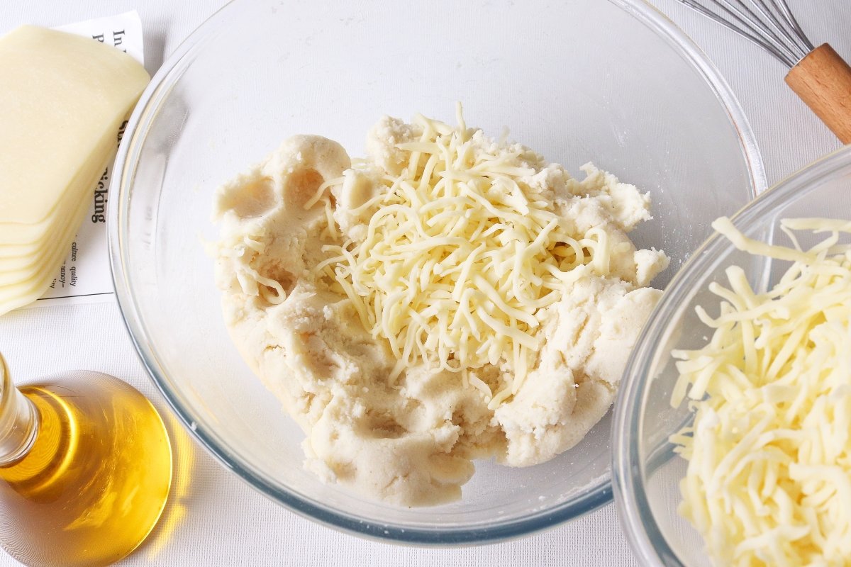 Añadir queso rallado a la masa de las arepas colombianas con queso