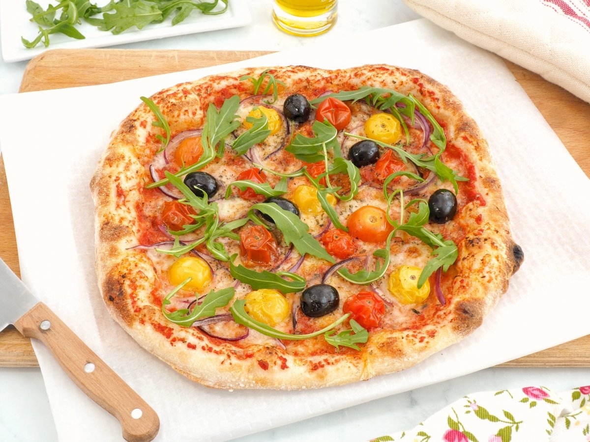 Añadir rúcula por encima de la pizza primavera