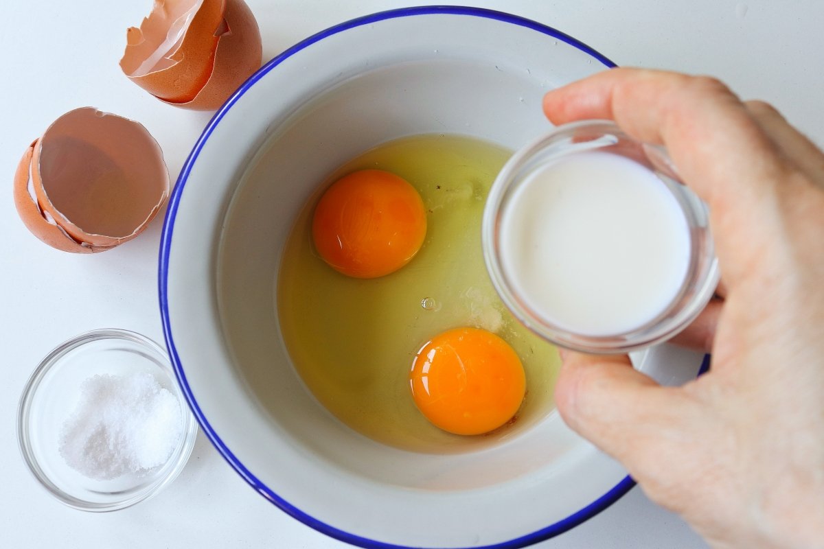 Añadir sal y leche a los huevos omelette de huevo