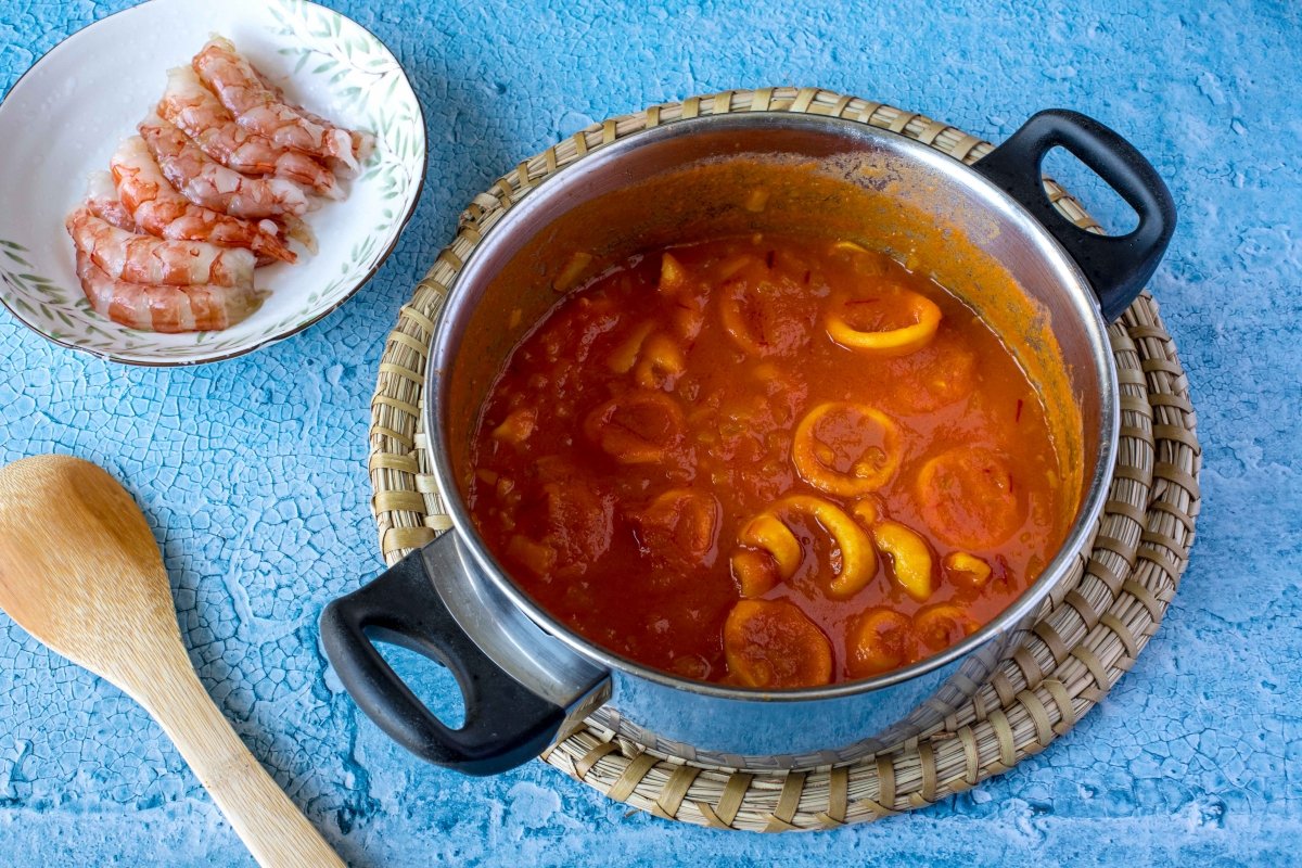 Añadir salsa de tomate, cocinar y añadir gambones para los tallarines a la marinera