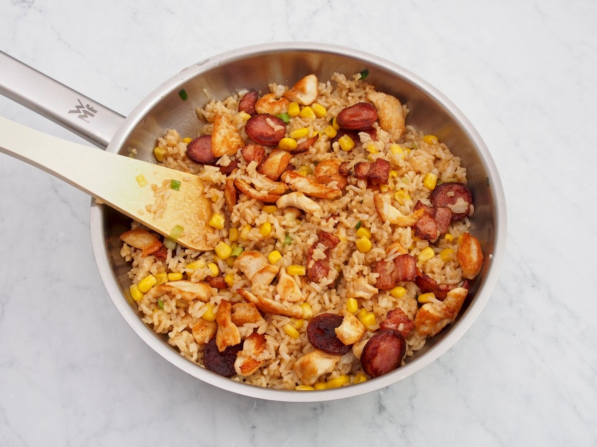 Añadir todas las carnes cocinadas al arroz paisa